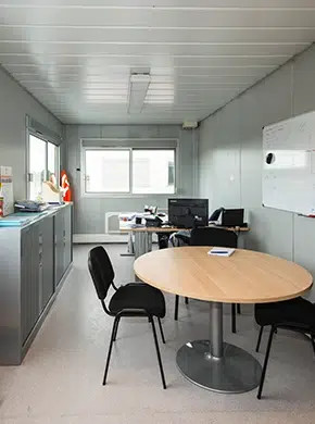Aménagement intérieur d'un bureau préfabriqué avec mobilier, éclairage et poste de travail
